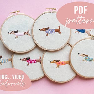 Könnte beinhalten: Sechs Stickrahmen mit verschiedenen farbigen Dackel-Designs. Die Rahmen befinden sich auf einem rosa Hintergrund. Der Text "PDF pattern" und "INCL. VIDEO tutorials" ist im Bild sichtbar.