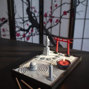 May include: A miniature zen garden with a red torii gate, a small pagoda, a stone path, and a candle in a bowl. The garden is set on a black tray with a wooden rake.