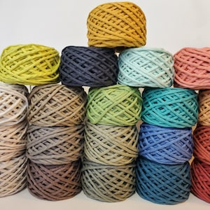 May include: A collection of 18 balls of yarn in various colors, including yellow, green, blue, brown, and pink. The yarn is arranged in a pyramid shape, with the largest ball at the top and the smallest balls at the bottom.
