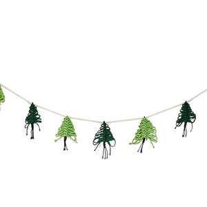 May include: A festive garland featuring a string of green Christmas tree ornaments. The trees vary in shades of green and are strung along a white cord. The garland is perfect for holiday decor.