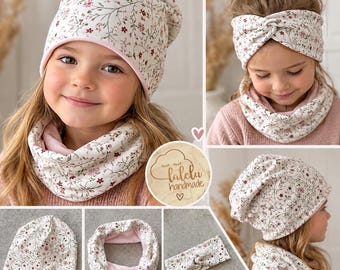 May include: A set of accessories featuring a floral pattern with small pink and dark red flowers on a cream background. The set includes a slouchy beanie, a twisted headband, and a circular infinity scarf, all lined with a solid light pink fabric.