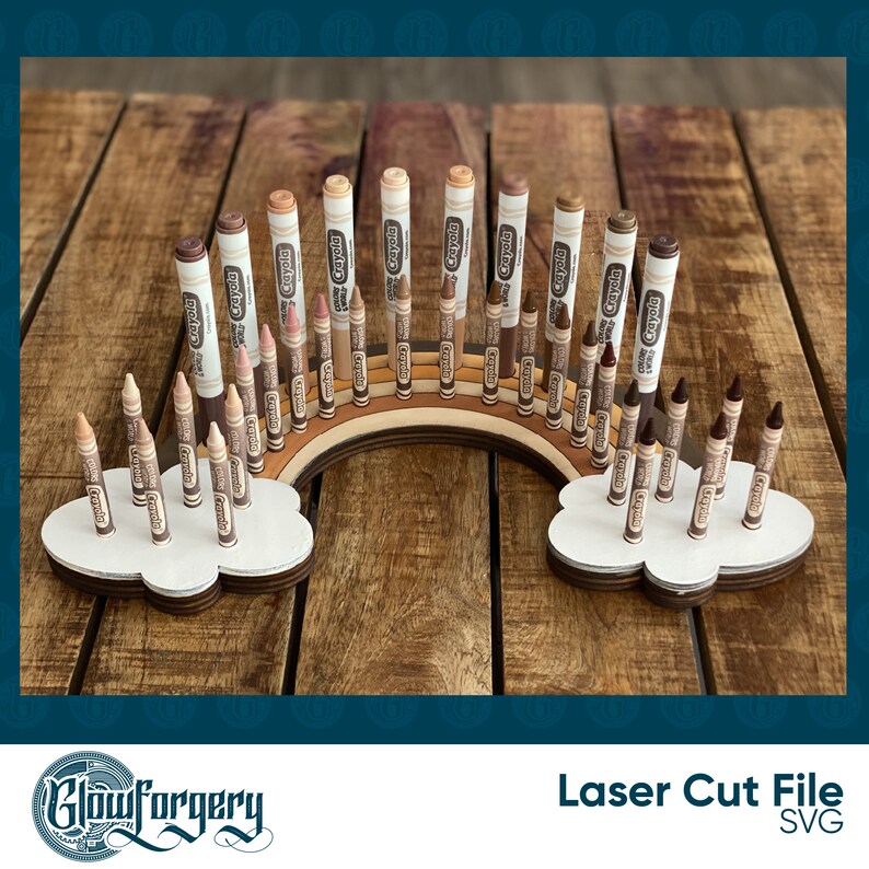 May include: A wooden rainbow-shaped stand with two cloud-shaped bases holds a collection of Crayola crayons in various shades of brown. The stand is designed to organise and display the crayons.