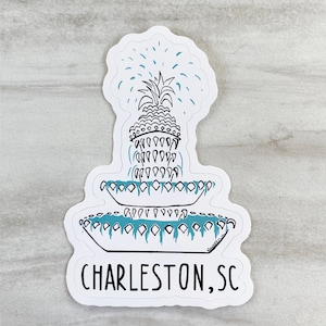 May include: White sticker featuring a black and white illustration of a pineapple fountain with blue water. The text "CHARLESTON, SC" is beneath the fountain.