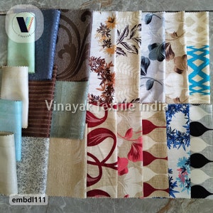 Puede incluir: Una colección de muestras de tela en varios colores y patrones, incluyendo diseños florales, geométricos y abstractos. Las muestras están dispuestas en una cuadrícula sobre una superficie marrón claro. El texto "Vinayak Textile India" es visible en el centro de la imagen. El texto "embdi111" es visible en la esquina inferior izquierda de la imagen.
