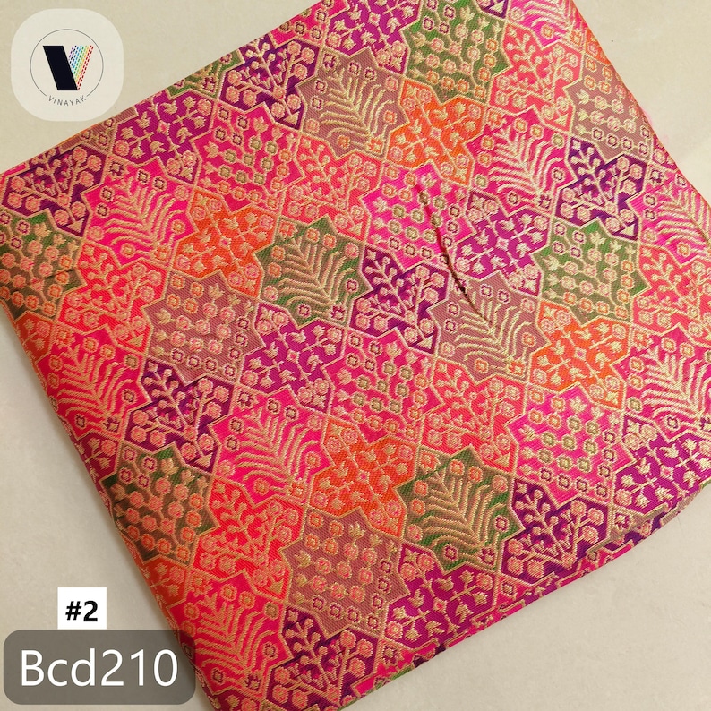 Puede incluir: Una tela doblada con un vibrante patr&oacute;n geom&eacute;trico en tonos de rosa, naranja, morado y verde. El dise&ntilde;o incluye formas florales y de estrella con detalles dorados. El texto "#2" y "Bcd210" es visible en la esquina inferior izquierda.