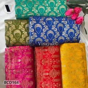 May include: A collection of colorful fabric rolls with intricate gold patterns. The fabrics are in shades of green, blue, pink, red, and yellow. The text "Vinayak" and "BCD164" are visible.