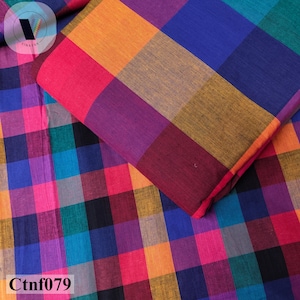 Peut inclure: Un morceau de tissu plié présentant un motif à carreaux multicolore et vif. Le textile affiche une grille répétitive de carrés dans des tons de rose vif, bleu profond, orange, violet, bleu sarcelle et noir. Le texte Ctnf079 est visible dans le coin.