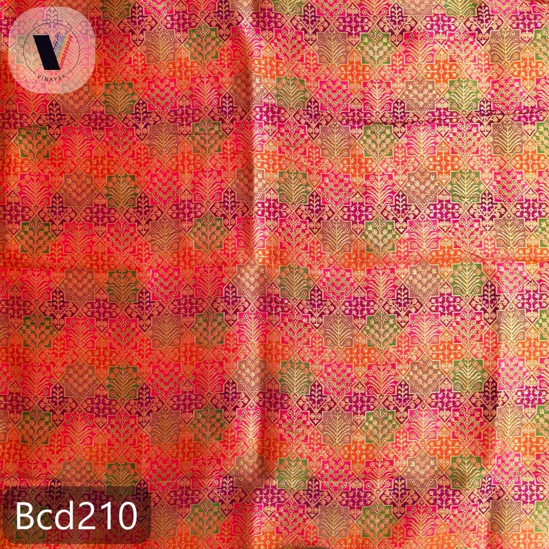 Puede incluir: Una tela vibrante con un patr&oacute;n geom&eacute;trico repetitivo en tonos naranja, rosa, verde y dorado. El dise&ntilde;o presenta motivos florales o de hojas estilizados. El texto "Bcd210" es visible en la esquina inferior izquierda.