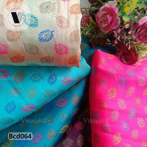 May include: Three different fabric swatches with a repeating pattern of colorful paisley designs. The swatches are in shades of cream, turquoise, and pink.