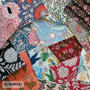 Może przedstawiać: Kolekcja kolorowych kwadratów tkaniny z kwiatowymi i geometrycznymi wzorami. Kwadraty tkaniny są pikowane i mają różne kolory, w tym czerwony, niebieski, zielony i żółty. Kwadraty tkaniny są ułożone w losowy wzór. Tekst "Qctbdl002" jest widoczny w lewym dolnym rogu obrazu.