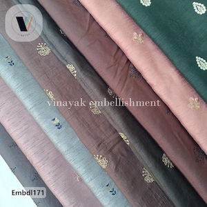 May include: A collection of six fabric swatches with different colors and patterns. The swatches are arranged in a fan shape, with the green swatch at the top and the gray swatch at the bottom. The swatches are all embroidered with small floral designs. The text "Embd1171" is visible at the bottom of the image.