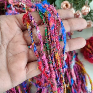 K&ouml;nnte beinhalten: Ein B&uuml;ndel bunter, mehrfarbiger und strukturierter Garne in den Farben Rosa, Blau, Gr&uuml;n und Rot. Das Garn ist weich und flauschig und eignet sich perfekt zum Stricken oder H&auml;keln.