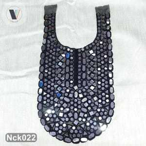 May include: A black fabric neckline applique featuring a dense arrangement of reflective, multi-shaped mirror pieces. The design includes a central vertical slit and a U-shaped collar, with various geometric shapes of mirrors stitched onto the dark mesh base.