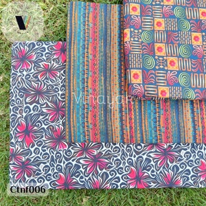 Puede incluir: Tres muestras de tela con diferentes patrones. La muestra superior tiene un patrón geométrico con colores naranja, verde y azul sobre un fondo azul oscuro. La muestra del medio tiene un patrón a rayas con colores naranja, azul y rojo sobre un fondo azul oscuro. La muestra inferior tiene un patrón floral con flores rosas sobre un fondo blanco y negro. El texto "Ctnf006" es visible en la esquina inferior derecha.