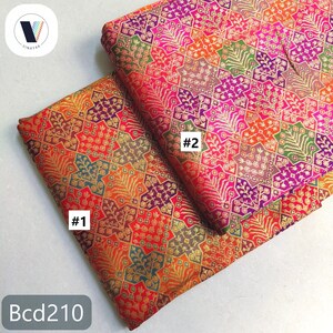 Puede incluir: Dos piezas de tela estampada con un dise&ntilde;o geom&eacute;trico. La tela presenta una vibrante mezcla de colores, incluyendo rojo, naranja, morado, verde y dorado. La tela est&aacute; etiquetada con los n&uacute;meros #1 y #2, y el texto "Bcd210".