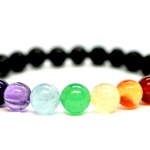 May include: A black lava rock bracelet with seven chakra beads. The beads are purple, light purple, light blue, green, yellow, orange, and red.