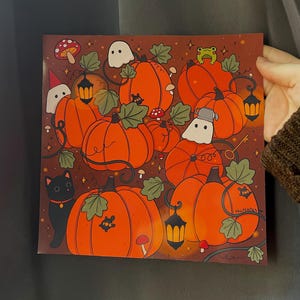 May include: A whimsical illustration of a group of orange pumpkins with green vines, leaves, and small mushrooms. There are also a black cat, a green frog, and two white ghosts. The text "thkcreates" is in the bottom right corner.