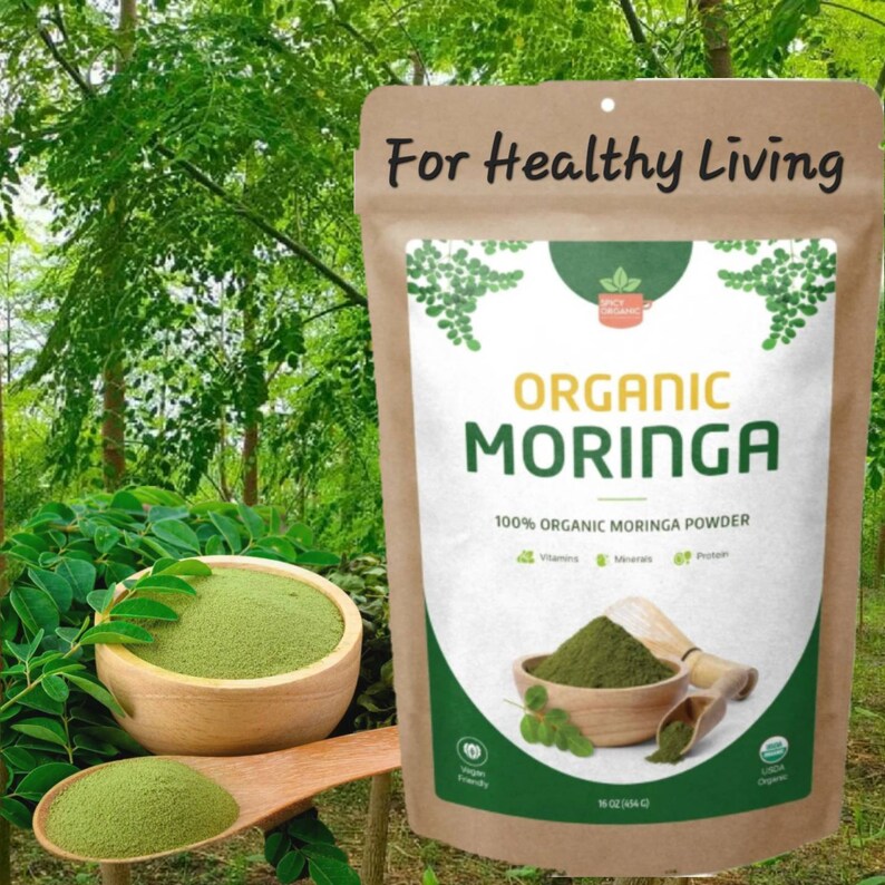 May include: A brown paper bag with a white label that says "For Healthy Living" and "Organic Moringa" with a green leaf design. The bag contains 454 grams of organic moringa powder.