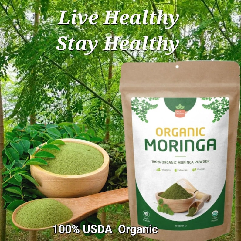 May include: A brown paper bag with a white label that says "Organic Moringa" and "100% Organic Moringa Powder". The bag is sitting on a wooden surface with a green leafy background. The text "Live Healthy Stay Healthy" is at the top of the image. The bag is 100% USDA Organic.