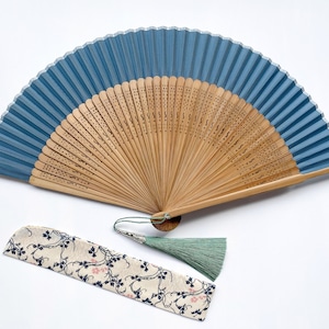 May include: A blue and bamboo folding fan with a floral patterned fabric case and a green tassel.