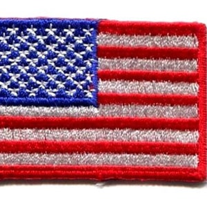 May include: A small embroidered American flag patch with red and white stripes and blue stars.