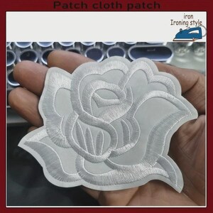 May include: A white embroidered rose patch featuring dense stitching and a defined floral silhouette. The design includes the text Patch cloth patch and iron Ironing style with a blue iron icon in the upper corner of the image.