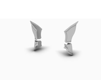 Op de afbeelding: Twee zilverkleurige, gesegmenteerde decoratieve stukken, die lijken op een harnas of een kostuumstuk, worden weergegeven op een witte achtergrond.