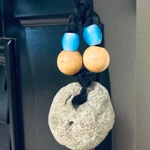 May include: A necklace with a light gray stone pendant, two light brown wooden beads, and two light blue glass beads.