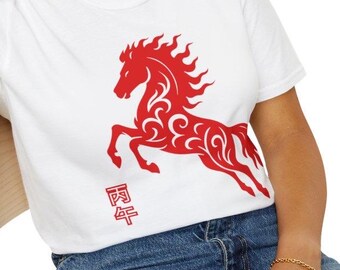 May include: White t-shirt featuring a red stylized horse design. The horse is depicted in a running pose with intricate patterns. The shirt also includes Chinese characters. The model is wearing blue jeans.