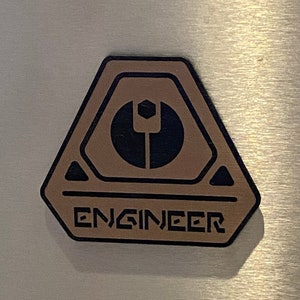 May include: A brown hexagonal sticker with a black symbol and the word "ENGINEER" in black lettering.