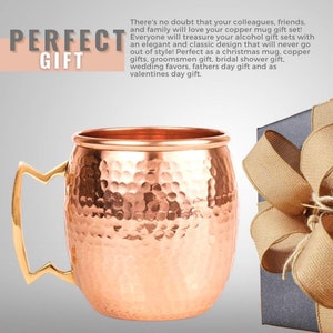 Puede incluir: Un mug de cobre martillado con un asa dorada. El mug es un regalo perfecto para cualquier ocasi&oacute;n, incluyendo bodas, cumplea&ntilde;os y d&iacute;as festivos. El mug se muestra junto a una caja de regalo con una cinta marr&oacute;n.
