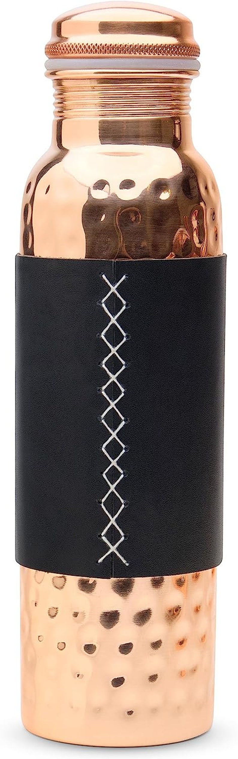 Puede incluir: Una botella de agua de cobre con un acabado martillado y una envoltura de cuero negro con costuras blancas. La botella tiene una tapa de cobre.