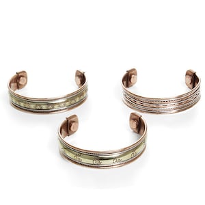 Puede incluir: Tres pulseras magn&eacute;ticas de cobre con diferentes dise&ntilde;os. Las pulseras son todas de cobre y tienen un cierre magn&eacute;tico. Las pulseras son de diferentes tama&ntilde;os y tienen diferentes dise&ntilde;os.