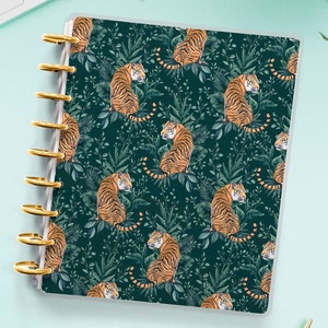 May include: A dark green planner with a gold coil binding. The cover features a repeating pattern of orange tigers in a jungle setting.