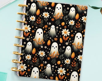 May include: A black and white planner with a repeating pattern of ghosts, flowers, and leaves. The ghosts are white with black eyes and smiles. The flowers are white with yellow centers. The leaves are green and orange. The planner has gold rings and a gold zipper.