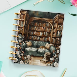 Peut inclure: Une couverture de planificateur avec une illustration fantaisiste d'une bibliothèque confortable avec un chat qui dort sur un canapé. La bibliothèque est remplie d'étagères et d'une grande fenêtre offrant une vue sur un ciel étoilé.