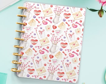 Op de afbeelding: Een witte plannerhoes met een herhalend patroon van aquarel illustraties. De illustraties omvatten harten, bloemen, enveloppen en theekopjes. De plannerhoes is ontworpen voor een planner in persoonlijke maat.