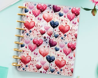 Op de afbeelding: Een witte plannerhoes met een herhalend patroon van roze, rode en blauwe aquarelhartjes met groene stelen en bladeren.