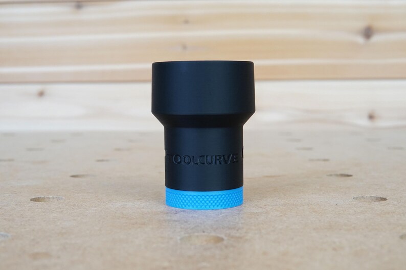 May include: A black tool with a blue ring at the bottom. The tool has the text "TOOLCURVE" printed on the side.