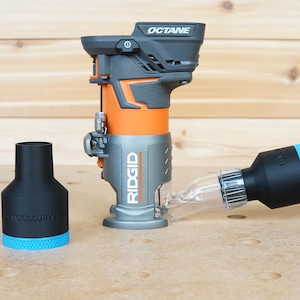 Pode incluir: Uma fresadora Ridgid preta e cinza com uma base laranja e um tubo de coleta de p&oacute; de pl&aacute;stico transparente conectado a uma mangueira de coleta de p&oacute; preta. A fresadora &eacute; etiquetada com "OCTANE" e "RIDGID".