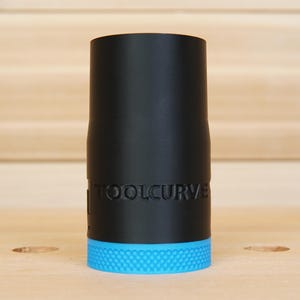 May include: A black cylindrical tool attachment with the text "TOOLCURVE" printed on the side. The base of the tool is a textured, bright blue. The tool is likely for woodworking or a similar craft.