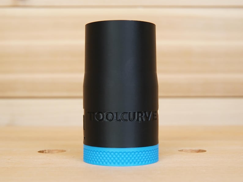 May include: A black cylindrical tool attachment with the text "TOOLCURVE" printed on the side. The base of the tool is a textured, bright blue. The tool is likely for woodworking or a similar craft.