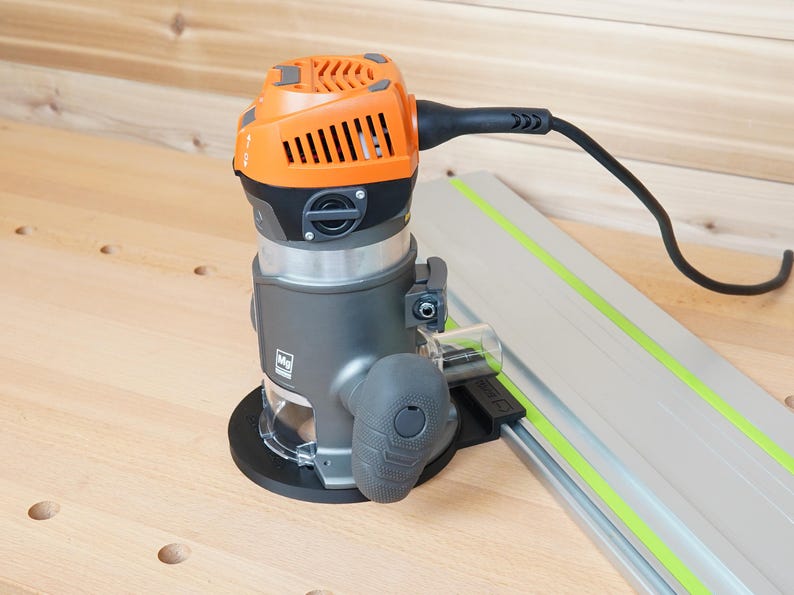 May include: An orange and gray power router with a black power cord and a silver guide rail. The router has a clear plastic guard and a black base. The guide rail has a green stripe.