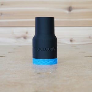 Peut inclure: Un adaptateur d'outil noir et bleu avec le texte "TOOLCURVE" imprim&eacute; sur le c&ocirc;t&eacute;.