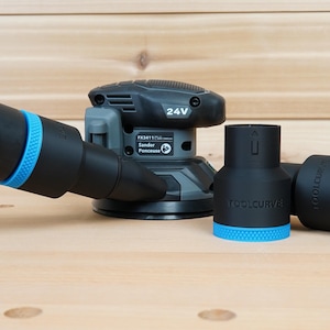 May include: A black and grey 24V sander with a dust collection system. The sander has a black and green hose and two black adapters with blue accents. The adapters are labelled "TOOLCURVE".