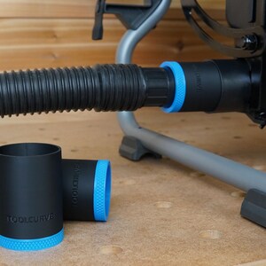 May include: Two black dust collection adapters with blue accents and the text "TOOLCURVE" printed on them. The adapters are designed to fit a dust collection hose.