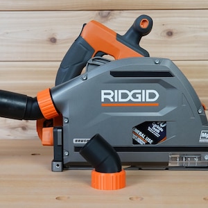 May include: A gray and orange RIDGID circular saw with a dust collection port and a black elbow attachment. The saw has a label that reads "General Use" and "24 Carbide Teeth".