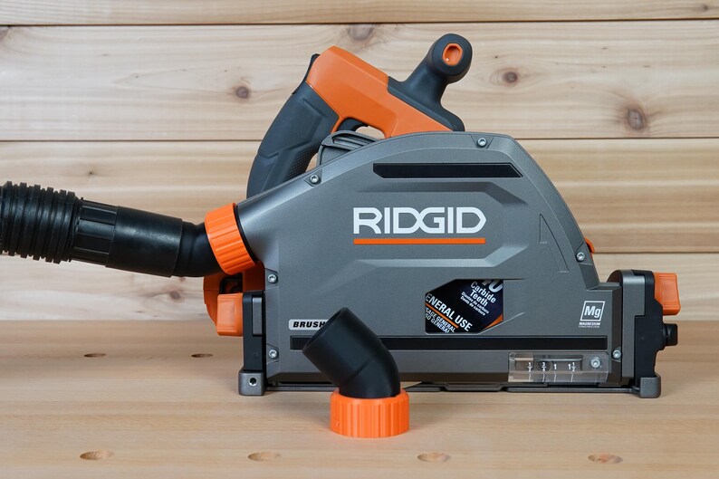 May include: A gray and orange RIDGID circular saw with a dust collection port and a black elbow attachment. The saw has a label that reads "General Use" and "24 Carbide Teeth".