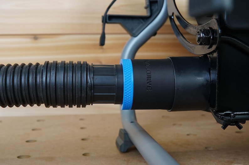 May include: Close-up of a black vacuum hose attachment with a blue ring and the text "VOLCURVE" printed on the side.