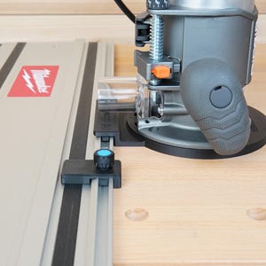 May include: A gray and black power router with a black handle and a silver guide rail. The guide rail has a red and white Milwaukee logo. The router is on a light wood surface.